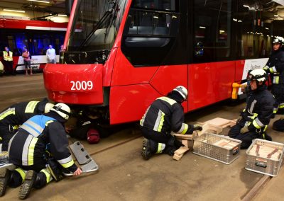 Üben für den Ernstfall: Feuerwehr hebt Straßenbahn an und bereitet die Bergung des Verletzten vor.