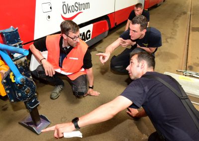 Üben für den Ernstfall: VAG-Mitarbeiter erläutert Feuerwehrmännern, wie die Straßenbahn angehoben wird.