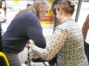 Daniela hilft Fahrgast aus dem Bus.